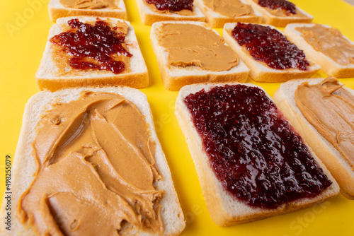 Close-up full frame shot of bread slices with preserves and peanut butter arranged alternatively