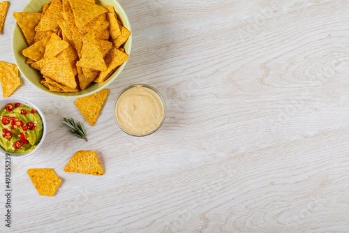 Directly above shot of two dipping sauces served with nacho chips in bowl on table with empty space