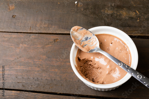Chocolate mousse served in ramekin bowl with spoon on table with blank space