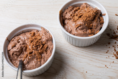 Close-up of chocolate mousse with cocoa powder served in ramekin bowls on table
