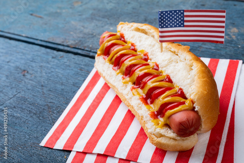 Close-up of hot dog with american flag on paper at table