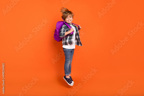 Foto Full body profile side photo of young boy jump hold backpack lesson isolated ove