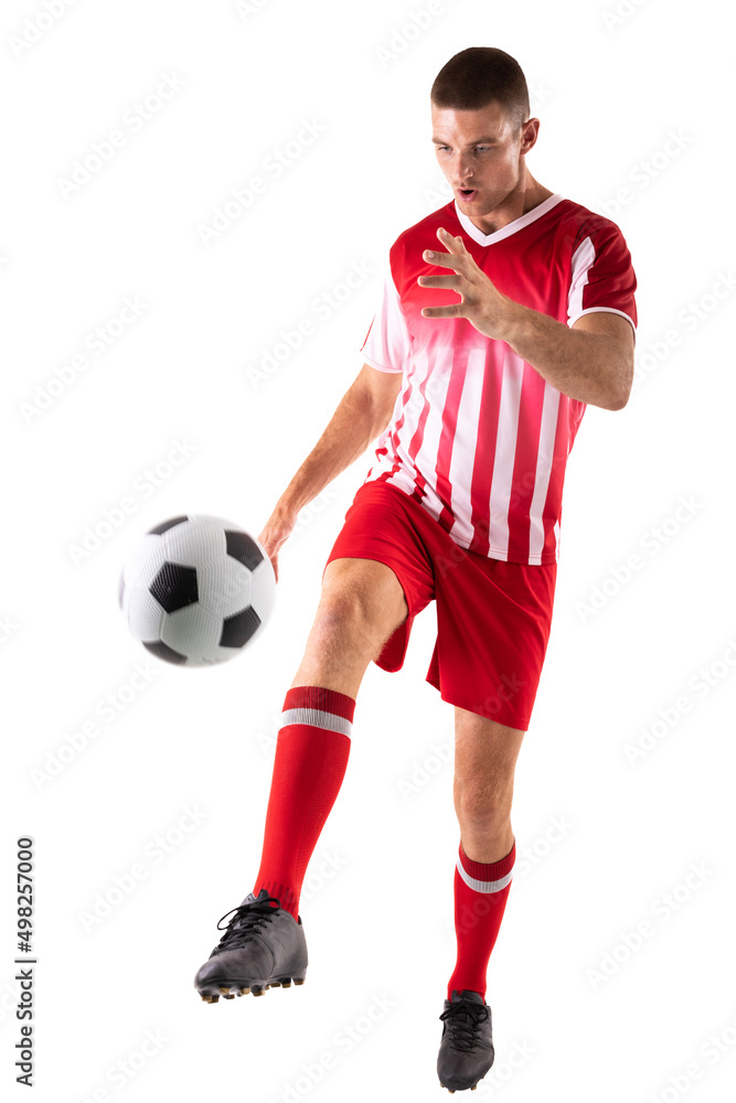 Confident young male caucasian athlete kicking soccer ball against white background