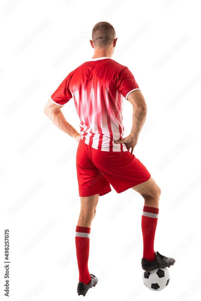 Full length rear view of young male caucasian athlete stepping on soccer ball over white background