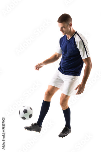 Full length of skilled caucasian male soccer player juggling ball on leg against white background