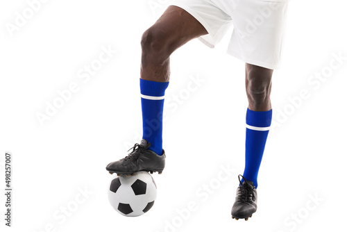 Low section of african american male player stepping on soccer ball over white background