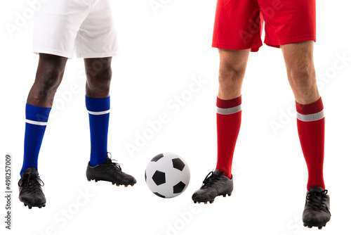Low section of young male multiracial soccer players standing by ball over white background