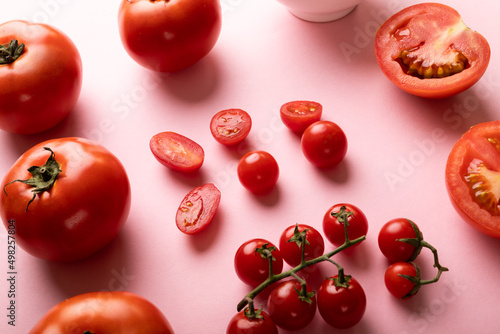 High angle view of fresh tomatoes and cherry tomatoes on pink background Fototapet