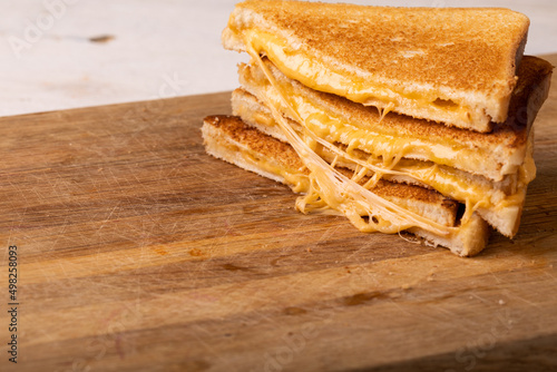 Close-up stack of fresh cheese sandwich served on wooden serving board
