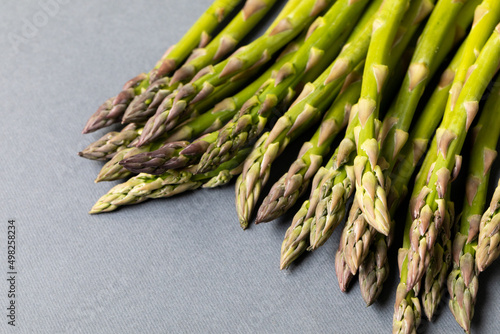 High angle close-up view of fresh asparagus over gray background