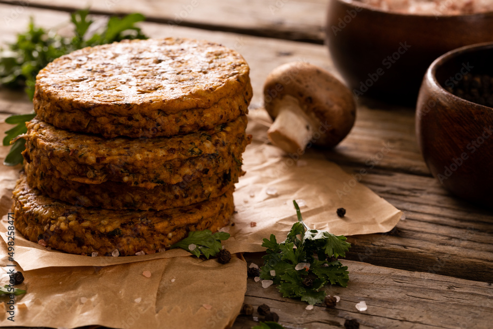 Fototapeta premium Close-up of patties stacked by edible mushroom on wooden table