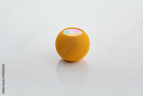 Smart round speaker in yellow color isolated on white.
