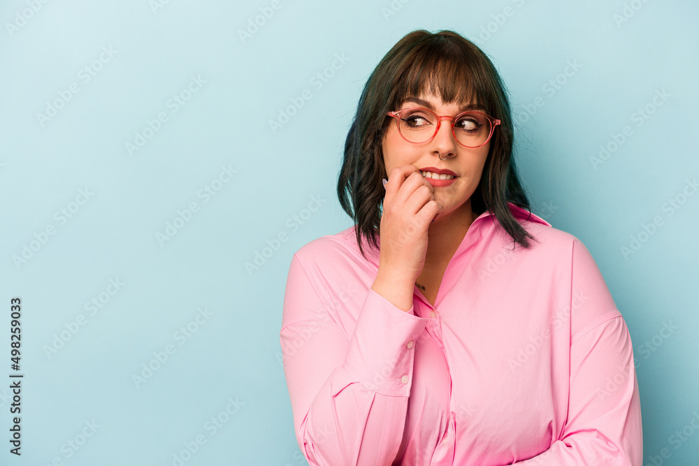 Young caucasian woman isolated on blue background relaxed thinking about something looking at a copy space.