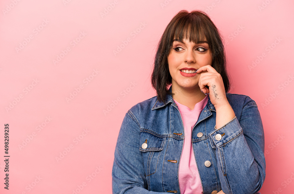 Young caucasian woman isolated on pink background relaxed thinking about something looking at a copy space. Young caucasian woman isolated on pink background relaxed thinking about something looking at a copy space.
