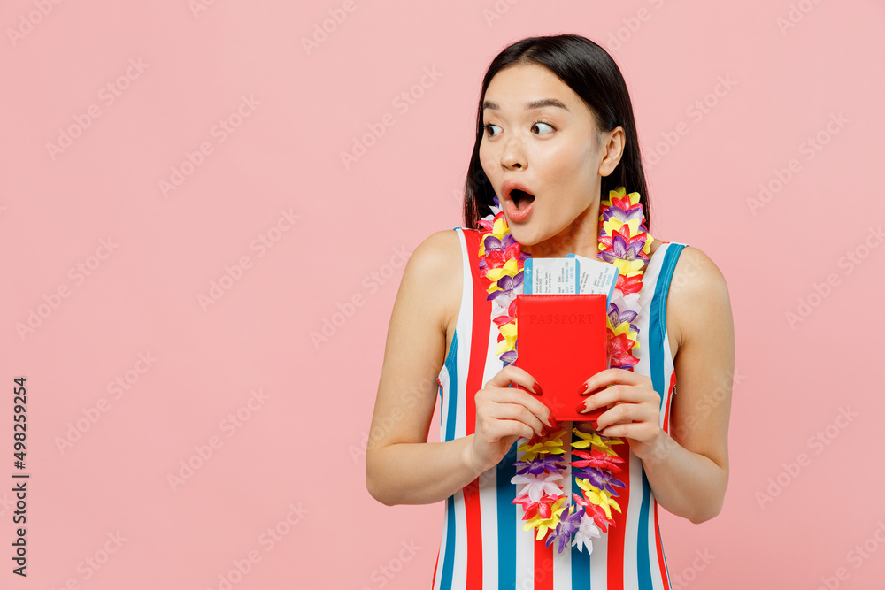 Traveler tourist woman of Asian ethnicity in swimsuit hold passport ticket show thumb up look aside isolated on pink background. Passenger travel abroad on weekends getawa. Air flight journey concept. Traveler tourist woman of Asian ethnicity in swimsuit hold passport ticket show thumb up look aside isolated on pink background. Passenger travel abroad on weekends getawa. Air flight journey concept.
