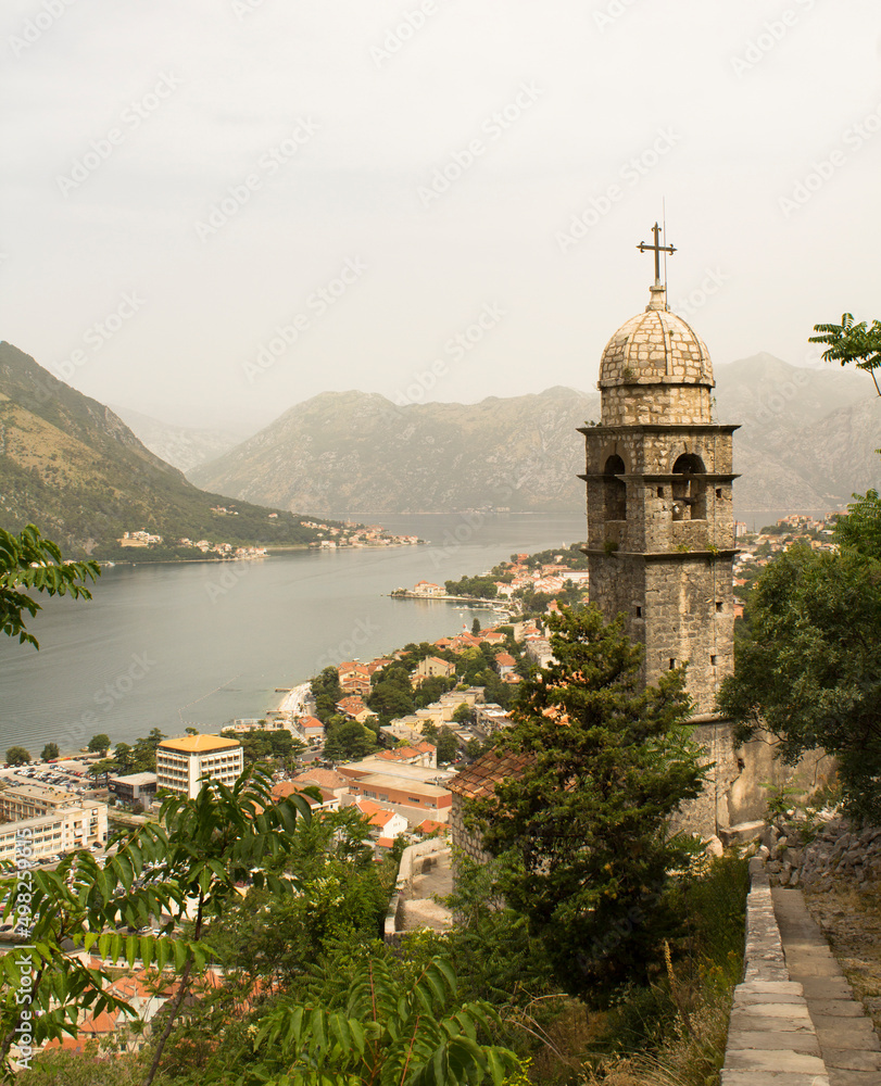 Close-up on the old tower and city on a summer day. Kotor. Montenegro. Location vertical.