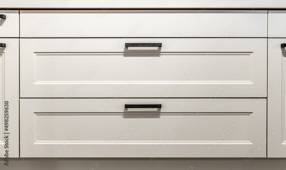 White kitchen cabinets with metal pulls or knobs on the doors. White kitchen cabinets with metal pulls or knobs on the doors.