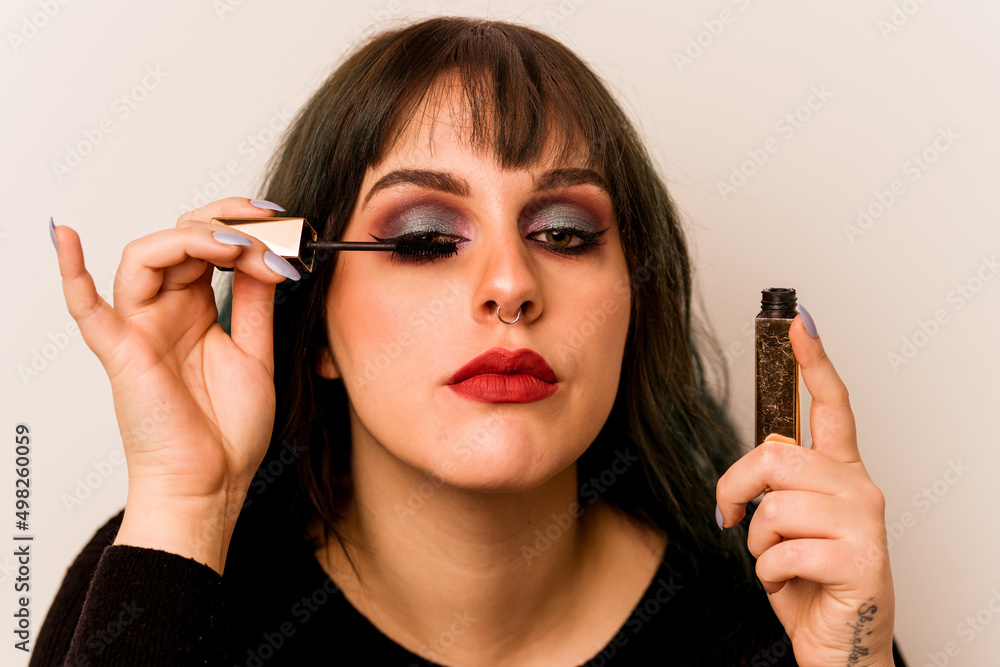 Obraz premium Young makeup artist woman holding a mascara isolated on white background