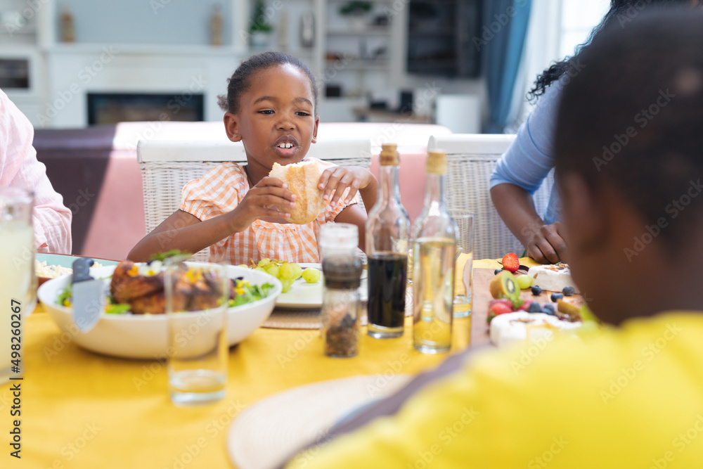 Cute african american girl having lunch with family at home on thanksgiving day Cute african american girl having lunch with family at home on thanksgiving day