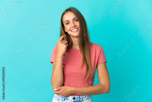 Young woman over isolated blue background laughing