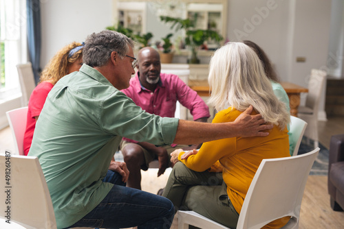 Foto Caucasian senior man consoling crying female during group therapy session