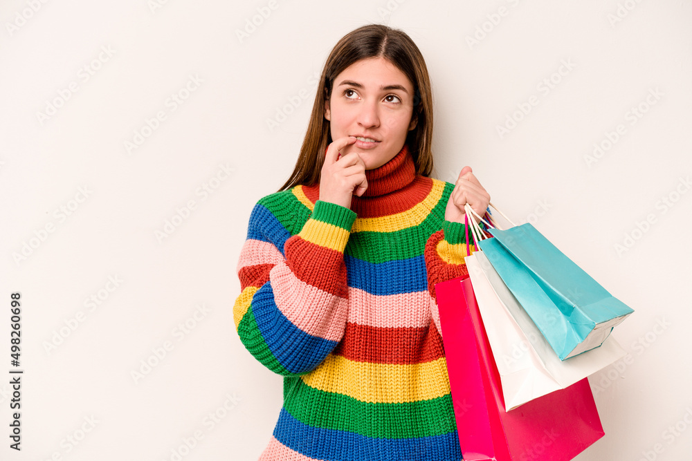 Young caucasian woman going to shopping isolated on white background relaxed thinking about something looking at a copy space. Young caucasian woman going to shopping isolated on white background relaxed thinking about something looking at a copy space.