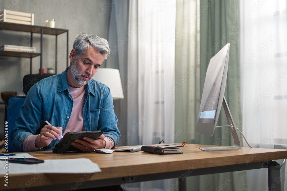 Mature man architect working on computer at desk indoors in office. Mature man architect working on computer at desk indoors in office.