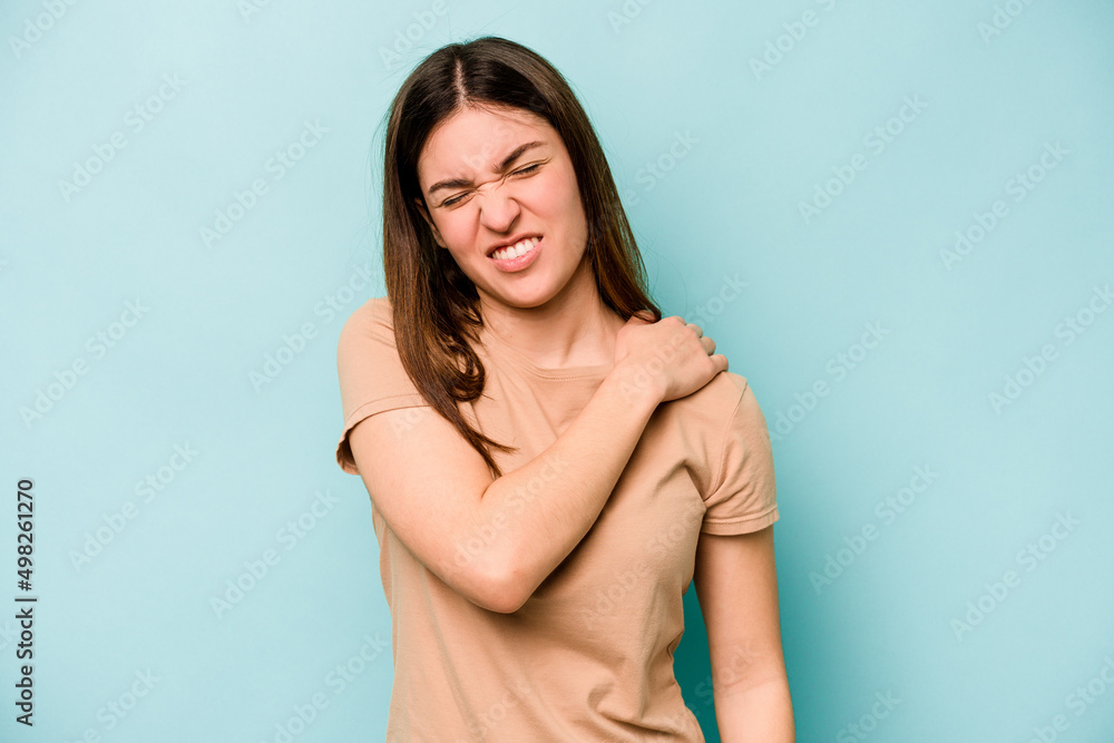 Young caucasian woman isolated on blue background having a shoulder pain. Young caucasian woman isolated on blue background having a shoulder pain.