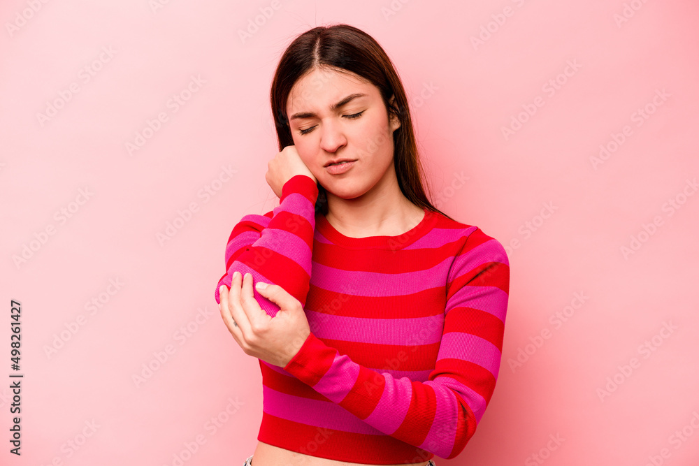 Young caucasian woman isolated on pink background massaging elbow, suffering after a bad movement. Young caucasian woman isolated on pink background massaging elbow, suffering after a bad movement.
