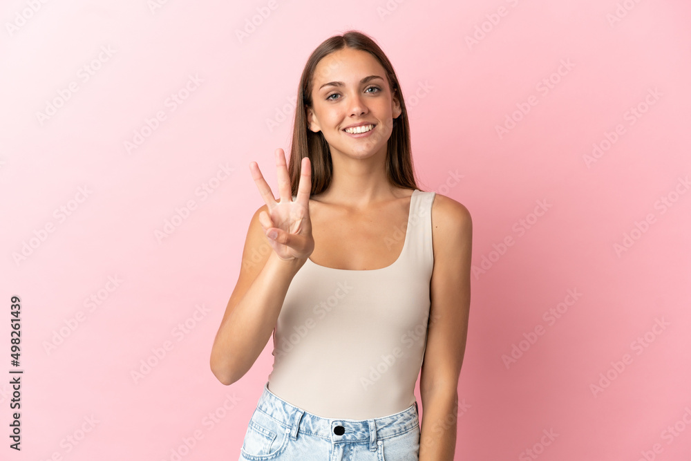 Young woman over isolated pink background happy and counting three with fingers Young woman over isolated pink background happy and counting three with fingers