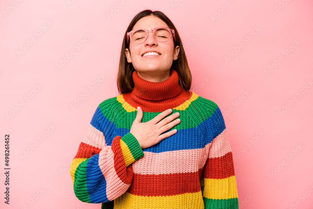 Young caucasian woman isolated on pink background laughs out loudly keeping hand on chest. Young caucasian woman isolated on pink background laughs out loudly keeping hand on chest.