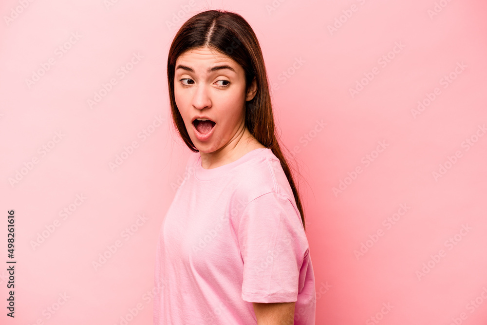 Fototapeta premium Young caucasian woman isolated on pink background looks aside smiling, cheerful and pleasant.