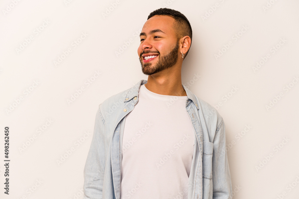 Young hispanic man isolated on white background relaxed and happy laughing, neck stretched showing teeth. Young hispanic man isolated on white background relaxed and happy laughing, neck stretched showing teeth.