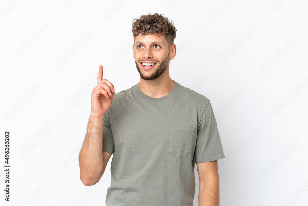 Naklejka premium Young caucasian handsome man isolated on white background pointing up and surprised