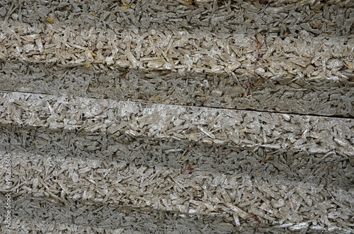 soundproof wall made of concrete porous ribbed material. fence of brown blocks inserted into metal beams, on the street. noise from road traffic does not get into the garden and residential area. photo