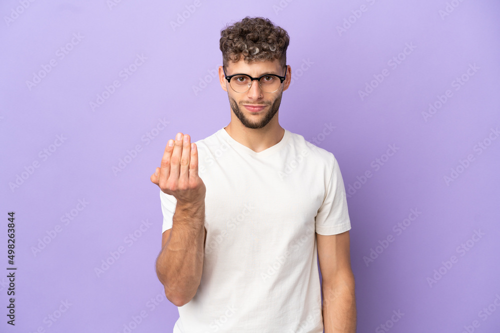 Delivery caucasian man isolated on purple background inviting to come with hand. Happy that you came Delivery caucasian man isolated on purple background inviting to come with hand. Happy that you came
