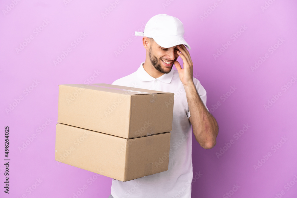 Delivery caucasian man isolated on purple background laughing Delivery caucasian man isolated on purple background laughing
