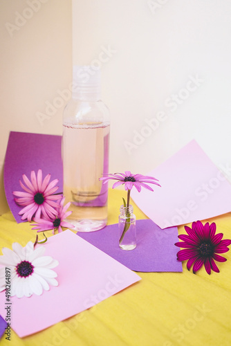 Still life of eco cosmetics with flowers in paper background design