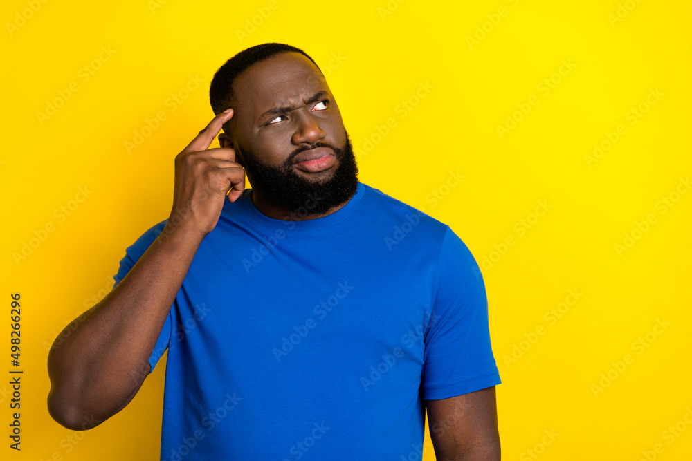 Portrait of attractive bewildered guy touching temple overthinking copy space isolated over vivid yellow color background Portrait of attractive bewildered guy touching temple overthinking copy space isolated over vivid yellow color background