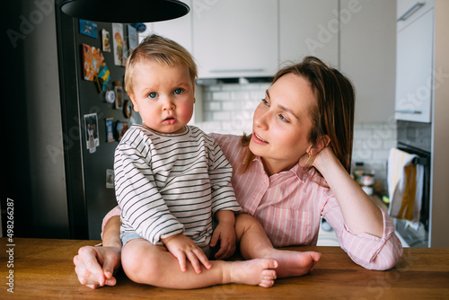 Mom plays at home with a small child on the couch, have fun.