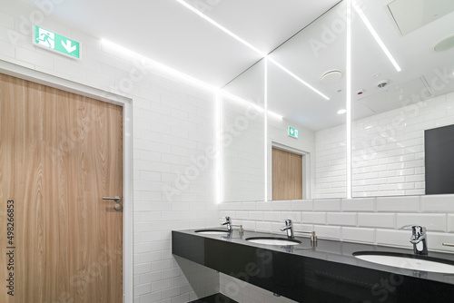 Nowoczesna łazienka z dużym lustrem na całą ścianie. Oświetlenie led sprytnie umieszczone w lustrze