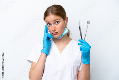 Dentist caucasian woman holding tools isolated on white background thinking an idea