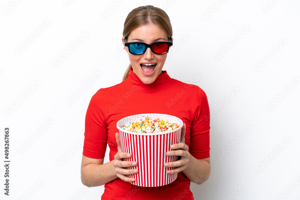 Young caucasian woman isolated on white background with 3d glasses and holding a big bucket of popcorns