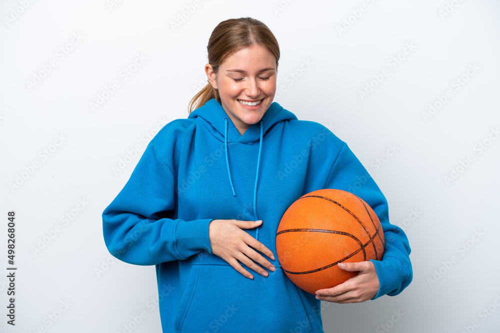 Young caucasian woman playing basketball isolated on white background smiling a lot