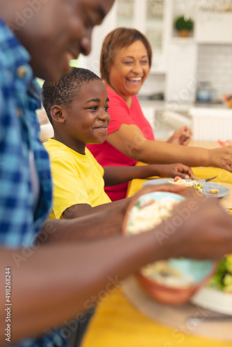 Smiling african american boy having lunch with family at home on thanksgiving day