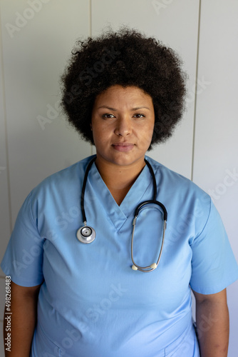 Portrait of confident african american mid adult female nurse with stethoscope standing in hospital