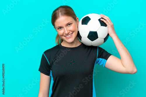Young caucasian woman isolated on blue background with soccer ball