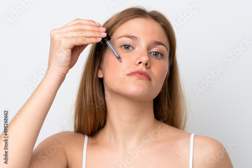 Young caucasian woman isolated on white background holding a serum. Close up portrait