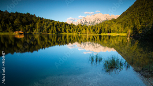 bavarian mountain lake with smooth reflections in the sundown lights