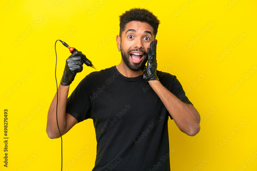 Tattoo artist man Brazilian man isolated on yellow background with surprise and shocked facial expression Tattoo artist man Brazilian man isolated on yellow background with surprise and shocked facial expression